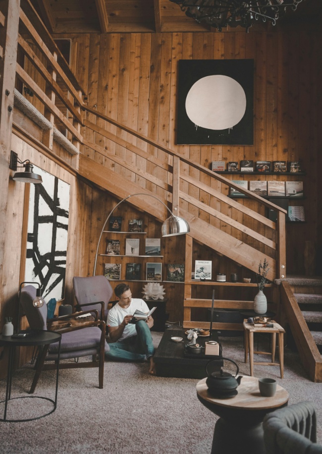 A man reading a book in a wooden room